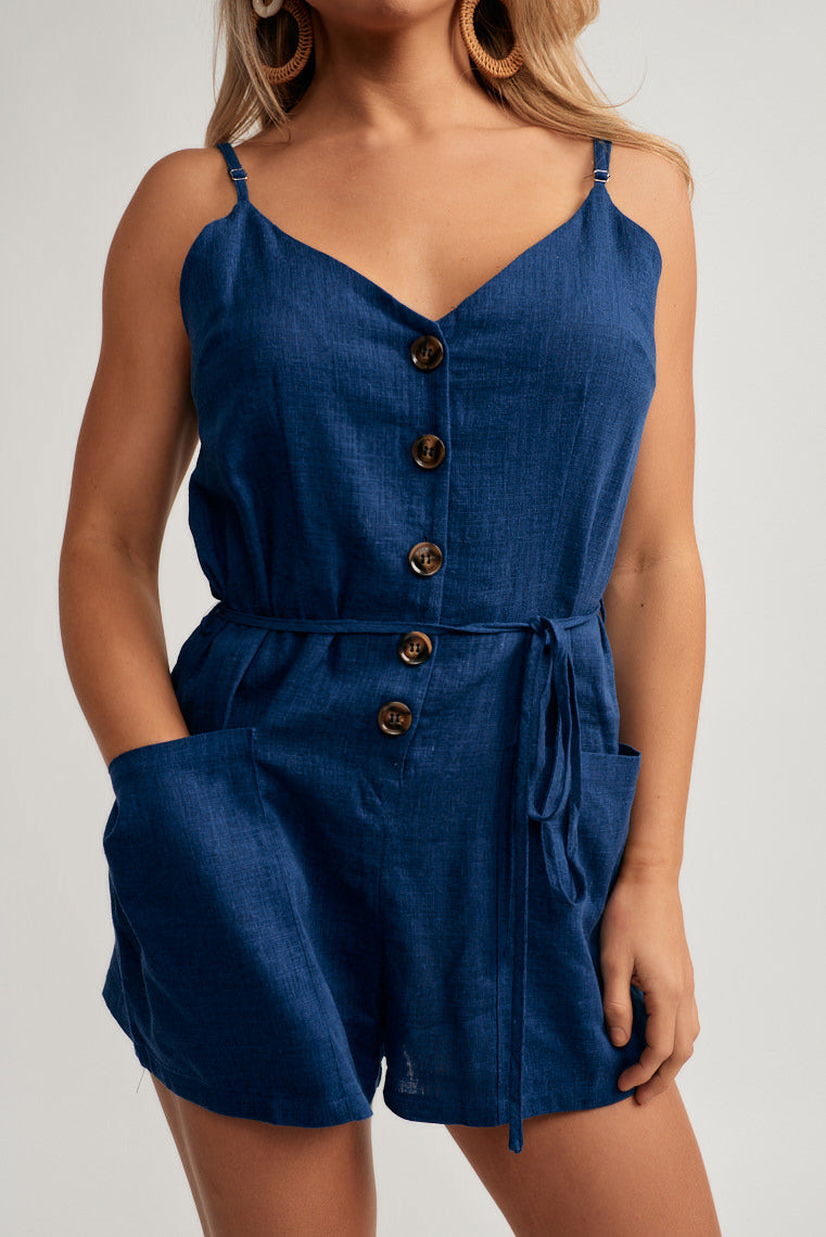 A v-neckline atop a relaxed bodice is supported by adjustable skinny straps and finished with relaxed shorts, tying waistline, and two side pockets.